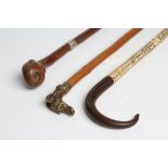 A VERTEBRAE WALKING CANE, 19th century, with metal tip and polished hardwood handle, 35" long,