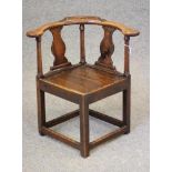 A GEORGIAN ELM CORNER CHAIR, 18th century, the bowed arm rail with broad rounded terminals, the