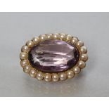 A VICTORIAN AMETHYST AND PEARL BROOCH, the oval facet cut amethyst collet set to a border of small