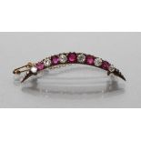 AN EDWARDIAN RUBY AND DIAMOND CRESCENT BROOCH alternately claw set with five graduated rubies and