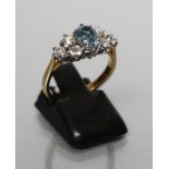 AN AQUAMARINE AND DIAMOND DRESS RING, the oval facet cut aquamarine claw set to shoulders each set