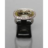 A MODERN DRESS RING, by David M Robinson, the oval facet cut stone (probably Lime Quartz),