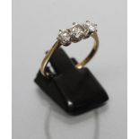 A THREE STONE DIAMOND RING, the old brilliant cut stones of approximately 0.5cts and 0.2cts claw set