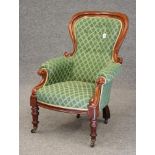 A VICTORIAN WALNUT FRAMED ARMCHAIR of spoon back form button upholstered in a cream and green weave,