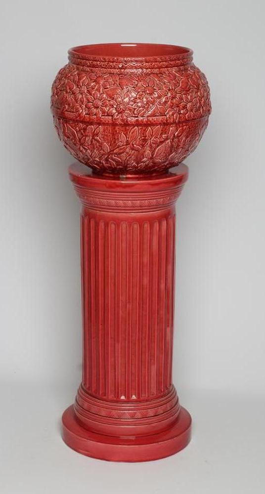 A BURMANTOFTS PINK GLAZED "FAIENCE" JARDINIERE AND STAND, early 20th century, the rounded pot