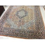 A PERSIAN STYLE CARPET, modern, the caramel floral field with navy and pale blue central gul,