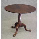 A GEORGE II MAHOGANY TRIPOD TABLE, the circular tip up top with bird cage action on turned gun