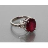 A RUBY RING, the oval facet cut stone of approximately 8cts claw set to angular shoulders each point