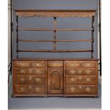 A GEORGIAN OAK DRESSER, mid 18th century, the delft rack with moulded cornice and waved frieze
