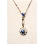 AN EDWARDIAN NECKLACE, the sapphire and seed pearl cluster hung from an open navette and single