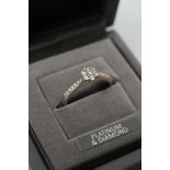 A DIAMOND CLUSTER RING, the seven round brilliants claw set to shoulders each point set with five