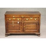 AN OAK ENCLOSED DRESSER, 19th century, the moulded edged plank top over two frieze drawers with