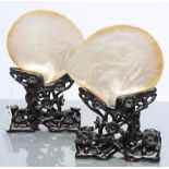 A PAIR OF CHINESE HARDWOOD STANDS carved and pierced with flowering prunus, supporting two