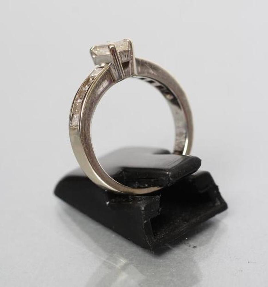 A DIAMOND RING, the baguette cut central stone of approximately 0.30cts claw set to shoulders each - Image 3 of 3
