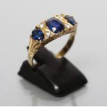 A SAPPHIRE HALF HOOP RING, the three graduated oval facet cut sapphires claw set and with four small