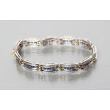 A SAPPHIRE AND DIAMOND BRACELET, the eleven oblong panels each centred by five square cut