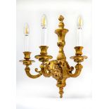 A SET OF FOUR GILT METAL THREE BRANCH WALL LIGHTS in the Louis XIV style, the acanthus sheathed
