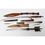 FOUR AFRICAN EDGED WEAPONS comprising two Bou Saa'da daggers with highly decorative wire wound grips