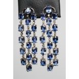 A PAIR OF SAPPHIRE CHANDELIER EARRINGS, each stud pendant with a strand of six claw set oval facet