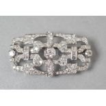 AN ART DECO DIAMOND BROOCH, the open oblong panel centred by an old brilliant cut stone of