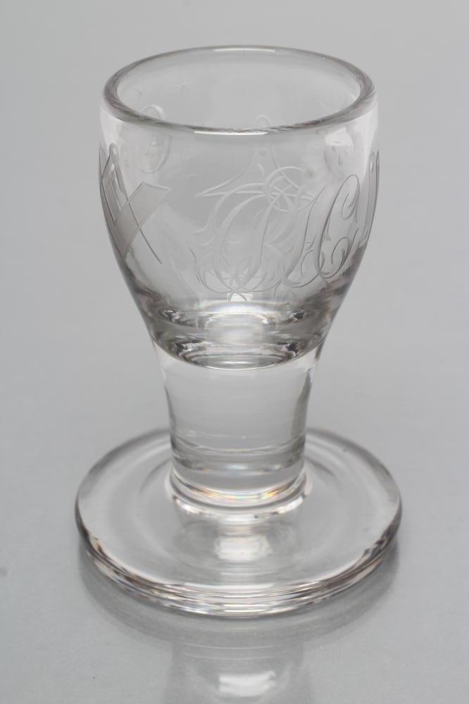 A FIRING GLASS, the bellied bowl engraved with Masonic symbols and initialled "RHC", on solid stem