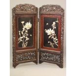 A CHINESE PADOUK WOOD AND IVORY FOLDING ROOM SCREEN, c.1900, comprising a pair of arched panels, the