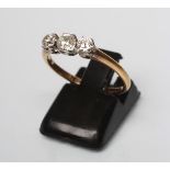 A THREE STONE DIAMOND RING, the three old brilliant cut stones claw set to a plain shank stamped