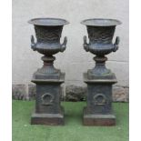 A PAIR OF CAST IRON URNS, modern, of campana form with ovolu rim, frieze of foliate scrolls, mask