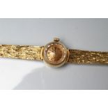 A LADY'S 18CT GOLD OMEGA WRISTWATCH, the brushed gilt dial with applied metal batons, the