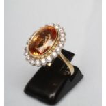 A CITRINE AND DIAMOND DRESS RING, the oval facet cut citrine of approximately 7.5cts, open back