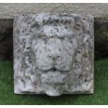 A CARVED STONE LION HEAD WALL FOUNTAIN, cut in high relief on a square back plate, 11 1/2" x 11 1/4"
