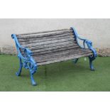 A VICTORIAN CAST IRON PARK BENCH, the open scrolled frame with slatted wood seat and back, lion head