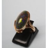 AN OPAL RING, the oval cabochon polished green stone in an art nouveau style rub-over setting to a