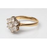 A DIAMOND CLUSTER RING, the seven round brilliants claw set to a plain 18ct gold shank, Sheffield,