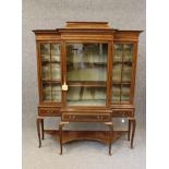 AN EDWARDIAN MAHOGANY DISPLAY CABINET of breakfront form crossbanded with stringing, moulded cornice