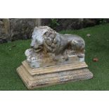 A STONEWARE FIGURE OF A RECUMBENT LION, after Canova, on stepped oblong base with foliate banding,