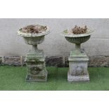 A COMPOSITE STONE URN, of fluted campana form, the shallow bowl with ovolo rim, on square base and