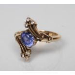 A SAPPHIRE AND DIAMOND COCKTAIL RING, the oval facet cut sapphire diagonally claw set to triple edge