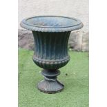A VICTORIAN CAST IRON GARDEN URN of half fluted campana form with ovolo moulded rim, turned stem and