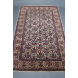 A PERSIAN RUG, the ivory field with repeating vase of flowers pattern in rose pink, green, red, navy