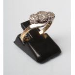 A THREE STONE DIAMOND RING, the old brilliant cut stones illusion set in platinum crossover to a