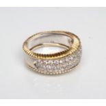 A DIAMOND HALF HOOP ETERNITY RING, the triple row of small stones point set in platinum to a wide