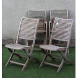 A SET OF FOUR TEAK FOLDING GARDEN CHAIRS with slatted seat and back on shaped square section