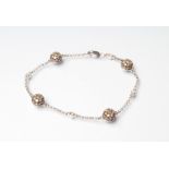A DIAMOND BRACELET, the four bosses each set with numerous brown stones with white diamond spacers