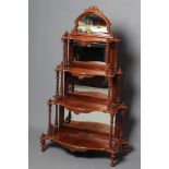 A VICTORIAN WALNUT MIRROR BACKED WHATNOT, of graduated four tier serpentine oblong form, arched