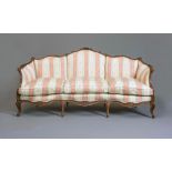 A LOUIS XVI STYLE WALNUT SHOW WOOD SOFA, c.1900, of serpentine outline carved with flowers and