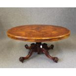 A VICTORIAN WALNUT LOO TABLE, the moulded edged quarter veneered tip up top on lobed baluster