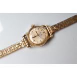 A LADY'S 18CT GOLD OMEGA "LADYMATIC" WRISTWATCH, the champagne dial with line batons, the