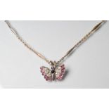 A BUTTERFLY PENDANT with diamond and ruby set wings and sapphire body, stamped 375, on an unmarked