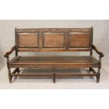 A GEORGIAN OAK SETTLE, mid 18th century, the back with leaf carved top rail with pointed finials